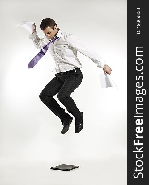 Young man jumping and stomping on a portfolio. Young man jumping and stomping on a portfolio