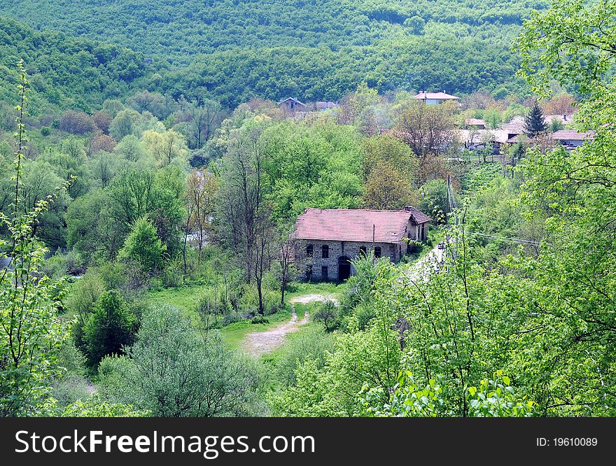 View of remote Bulgarian village in Balkan region with abandoned mill building in the center. View of remote Bulgarian village in Balkan region with abandoned mill building in the center