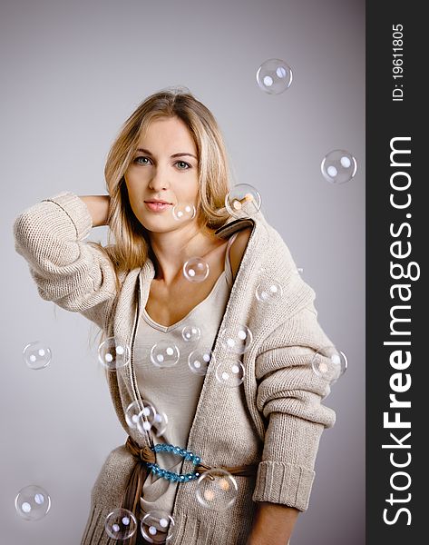 Smiling beautiful blond girl and soap bubbles