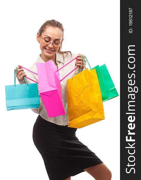 Businesswoman peeping in shopping bags over white. Businesswoman peeping in shopping bags over white