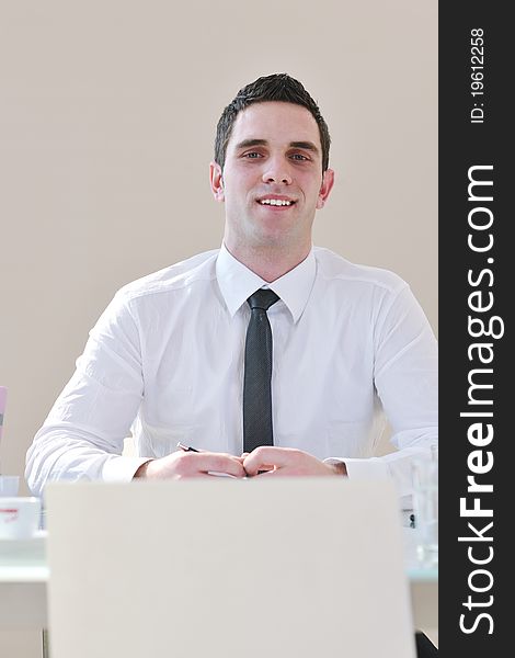 Young business man lawyer with laptop alone in big bright   conference room. Young business man lawyer with laptop alone in big bright   conference room