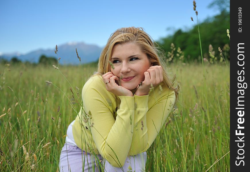 Beautiful natural woman with pure healthy skin outdoors on spring field. Switzerland. Beautiful natural woman with pure healthy skin outdoors on spring field. Switzerland