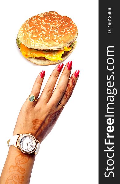 Female hand reaching cheese burger on white background. Female hand reaching cheese burger on white background.
