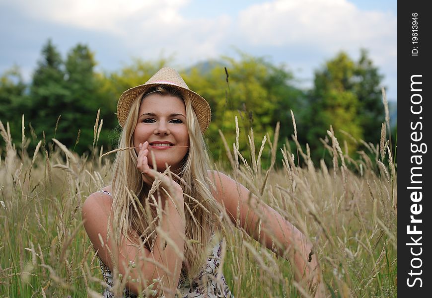 Pretty summer woman on yellow wheat field