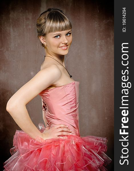 Portrait of the beauty young blond girl near the brown wall