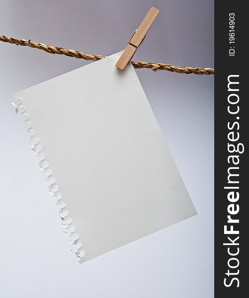 Close up of note pad and clothespins attached to a rope on white background. Close up of note pad and clothespins attached to a rope on white background