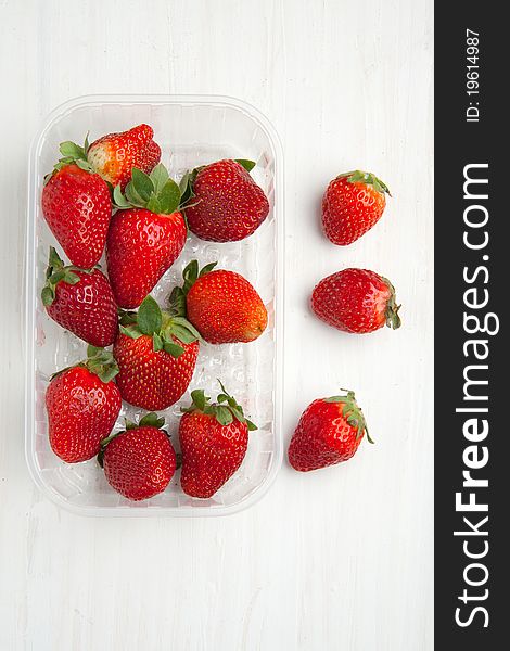 Top view on box of fresh strawberries on white table. Top view on box of fresh strawberries on white table