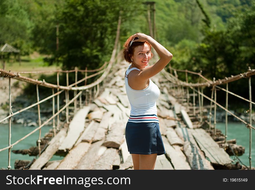 Young beautiful girl looked back going over the bridge. Young beautiful girl looked back going over the bridge