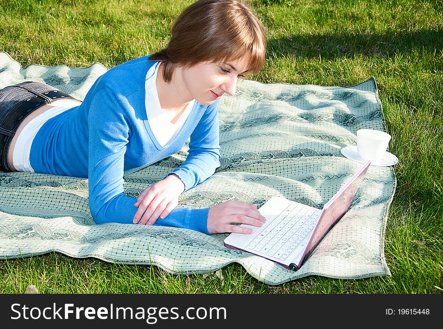 Beautiful girl working on laptop in the park