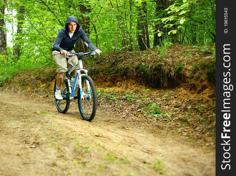 Young man on a bicycle in forest