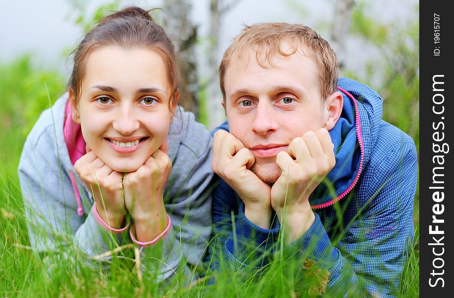 Portrait Of A Happy Couple Lying Together On Grass