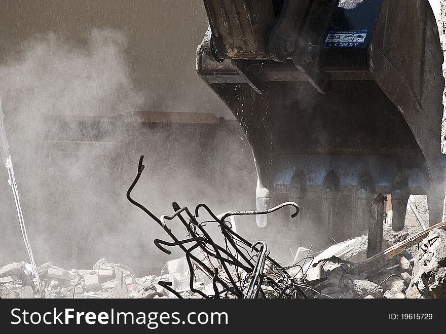 Indrustrial machine demolishing a building in ruins