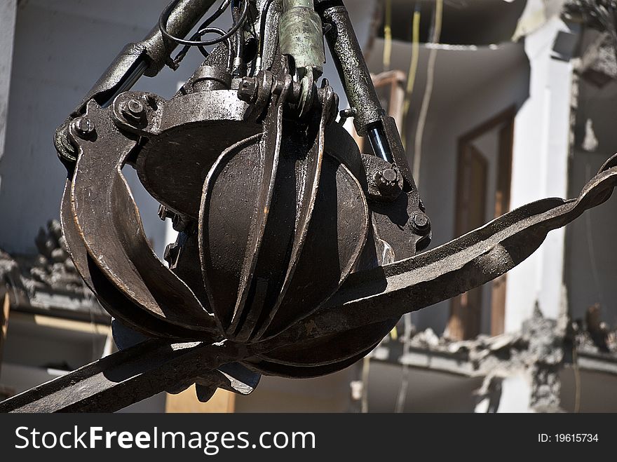 Indrustrial machine demolishing a building in ruins