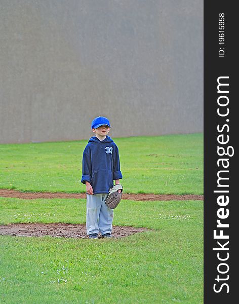 T-Ball player standing in the rain