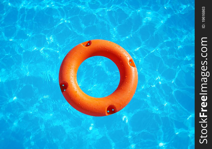 Bright orange life buoy floating on the surface of blue water