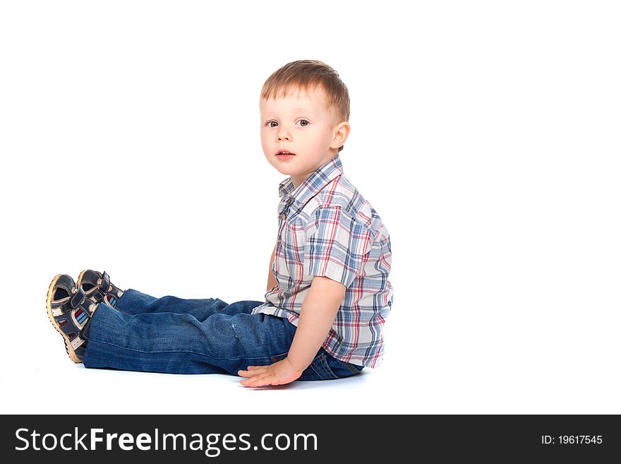 Cute little boy sitting isolated on white background. looking at camera. concept. Cute little boy sitting isolated on white background. looking at camera. concept.