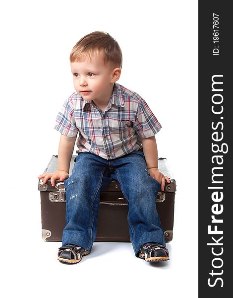 Two, three years old baby boy sitting on big suitcase isolated on a white background. transportation, moving, journey concept.