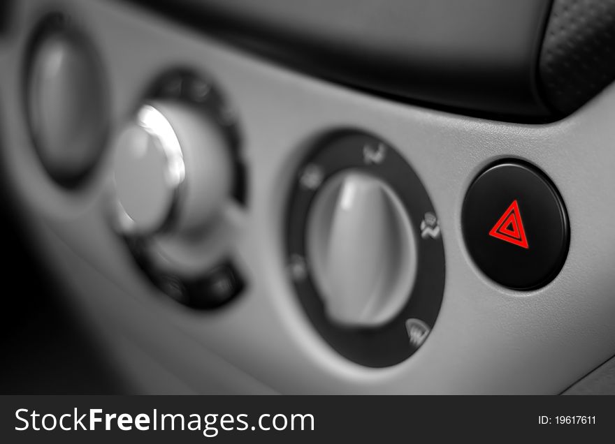 Red Emergency Button on a Dashboard of Car. Black and White image with Red Button