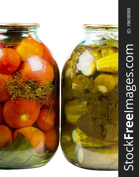 Two jars of pickles and tomatoes isolated over white background