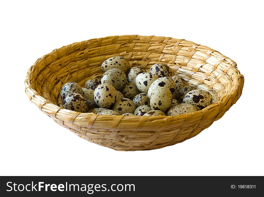 Quail eggs in wicker basket isolated on white background