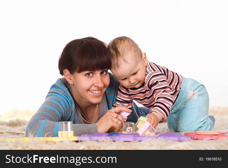 Happy mother and child playing on the carpet. Happy mother and child playing on the carpet