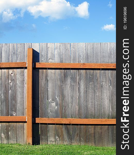 Fence with blue sky above it and green grass below it. Fence with blue sky above it and green grass below it.