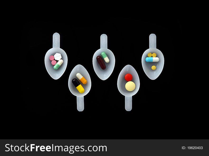 Pills spoon isolated on dark background