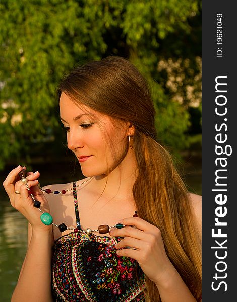 Portrait of a beautiful Russian girl with a beads on a background of green. Portrait of a beautiful Russian girl with a beads on a background of green