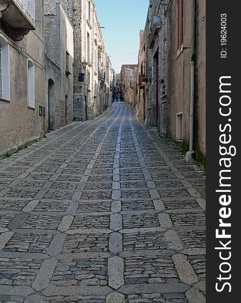 A narrow cobblestone road in the medieval town of Erice, Sicily.