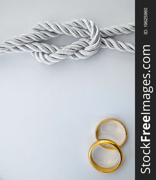 Silver rope tied and a double gold ring. Silver rope tied and a double gold ring