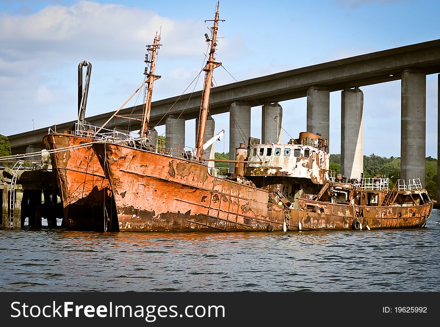 Old rusted ship, abandoned below the bridge