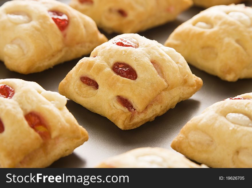 Strawberry strudel bites in rolls on a cookie sheet. Strawberry strudel bites in rolls on a cookie sheet.