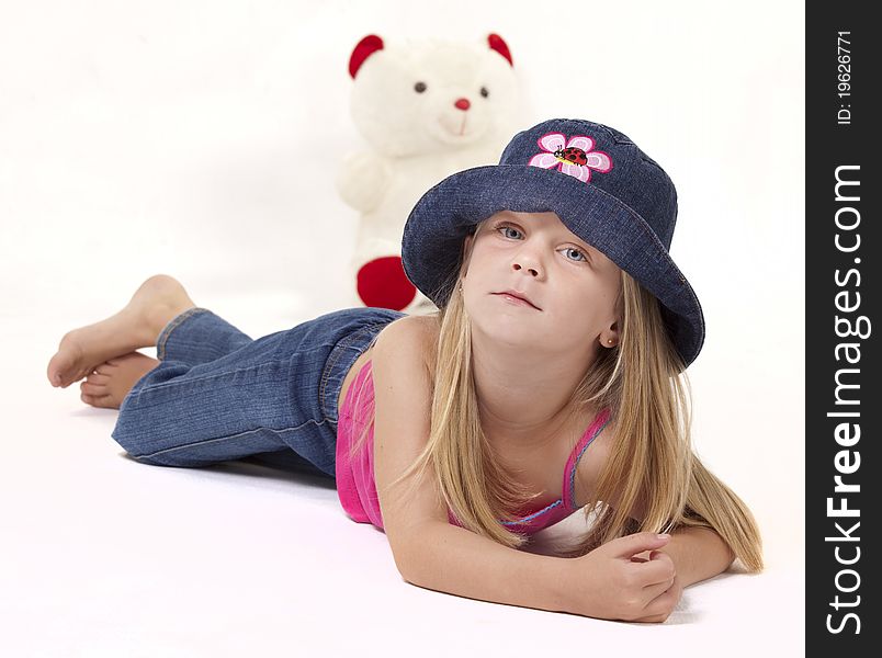 Little girl with playful denim hat and pink outfit on white background. Little girl with playful denim hat and pink outfit on white background.