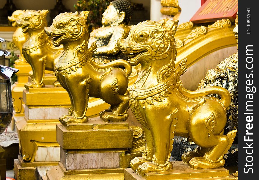 Thai lions statue standing in front of the temple entrance