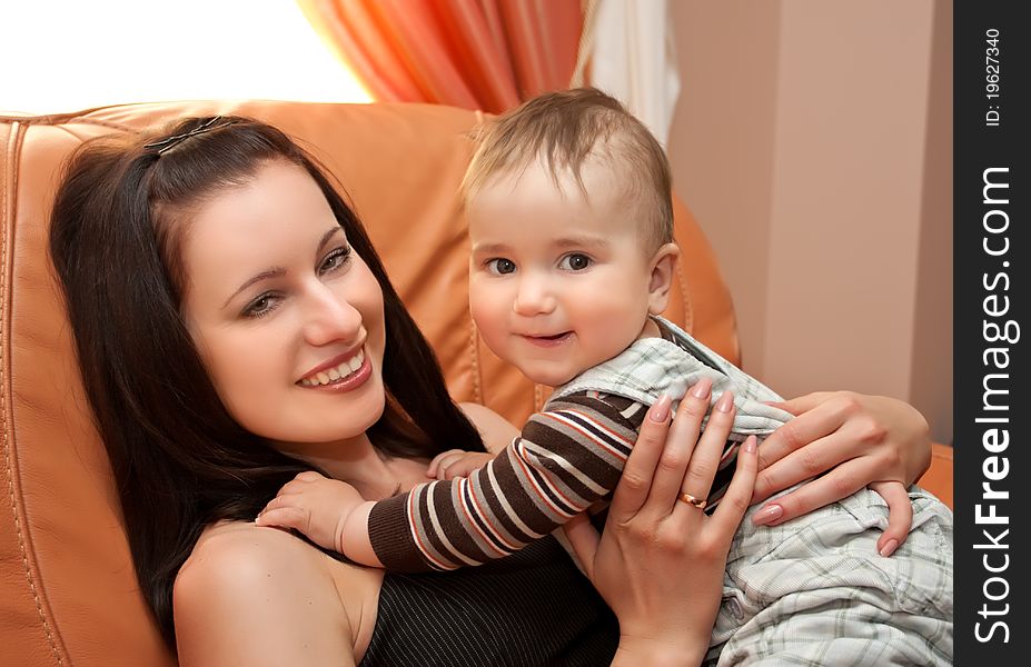 Mother with her sun sit on sofa and smiling. Mother with her sun sit on sofa and smiling