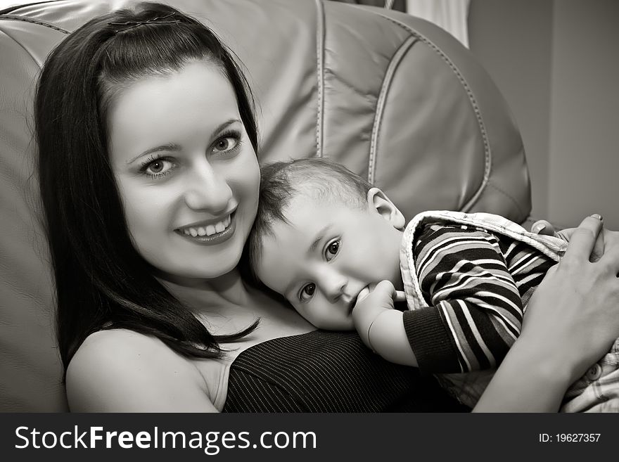 Mother with her sun sit on sofa and smiling. Mother with her sun sit on sofa and smiling