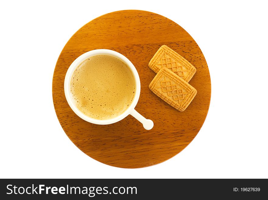 White ceramic cap of coffee standing on a round wooden saucer and two biscuits on the side, isolated (seen from above). White ceramic cap of coffee standing on a round wooden saucer and two biscuits on the side, isolated (seen from above)