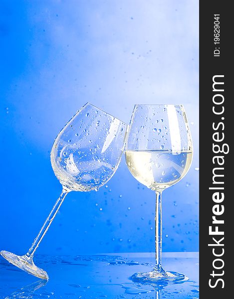 Two glasses with water on blue background