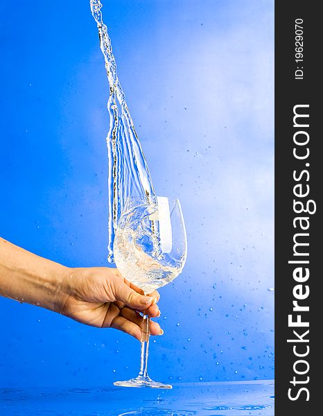 Splashing water in glass in hand