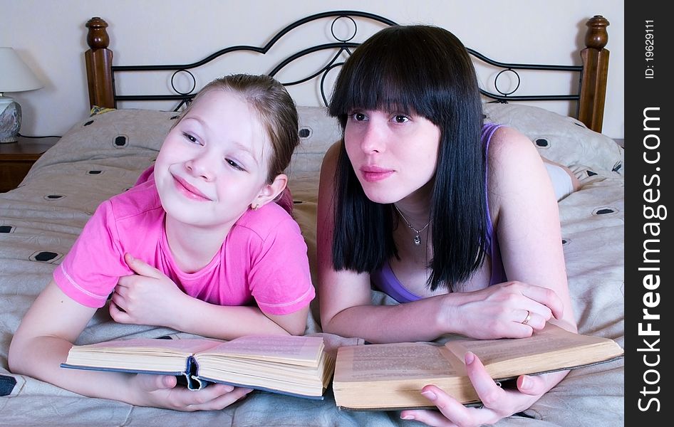 Mother and daughter reading in bed book