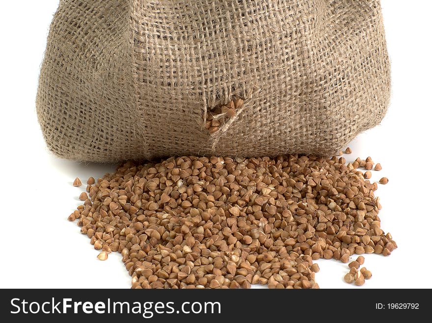 Scattered bag with buckwheat on white background