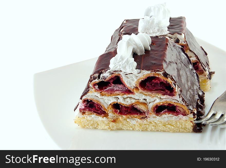 Piece of cake with chocolate glaze is isolated on a white background