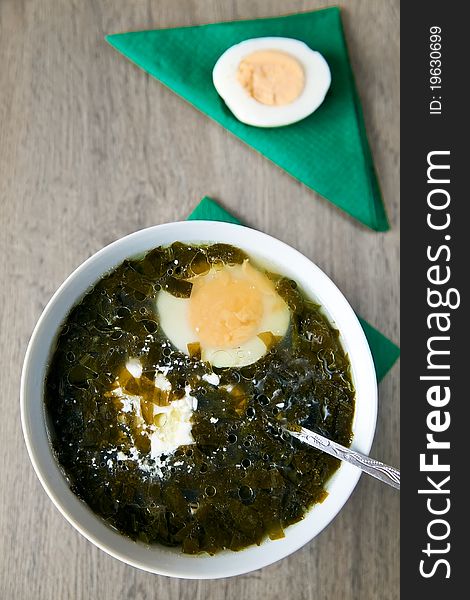 Close-up traditional spring meal - sorrel soup, serving with eggs and sour cream. Close-up traditional spring meal - sorrel soup, serving with eggs and sour cream