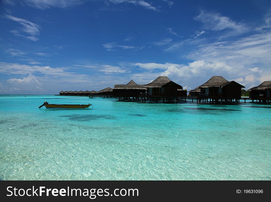 Turquoise seascape with blue sky, cloudscape and Maldives shoreline in background,water villas. Turquoise seascape with blue sky, cloudscape and Maldives shoreline in background,water villas