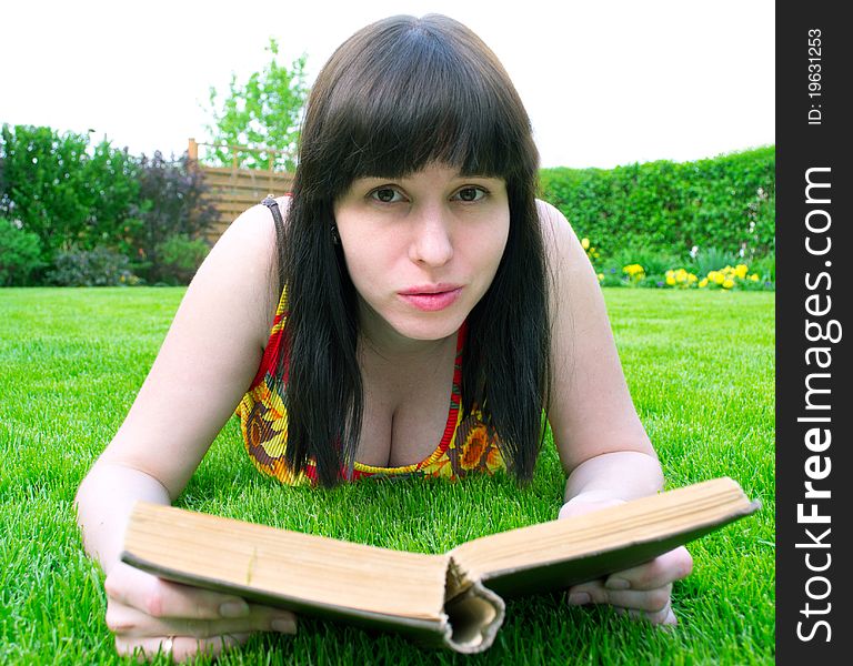 Woman on green grass reading a book. Woman on green grass reading a book