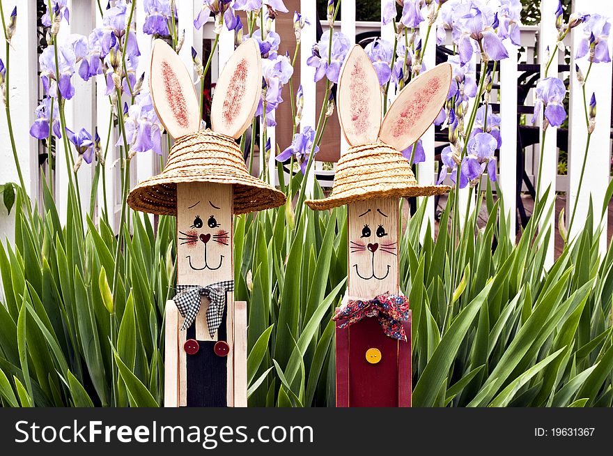 Two wood rabbit figures with spring flower background. Two wood rabbit figures with spring flower background