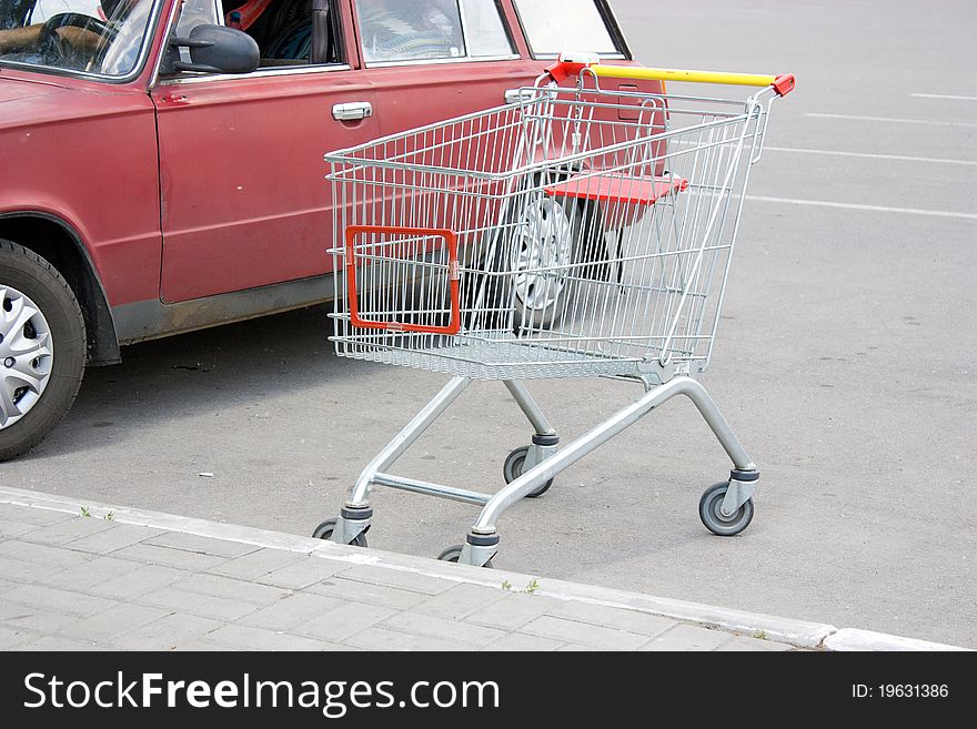 Shopping cart is parked in the parking lot for cars