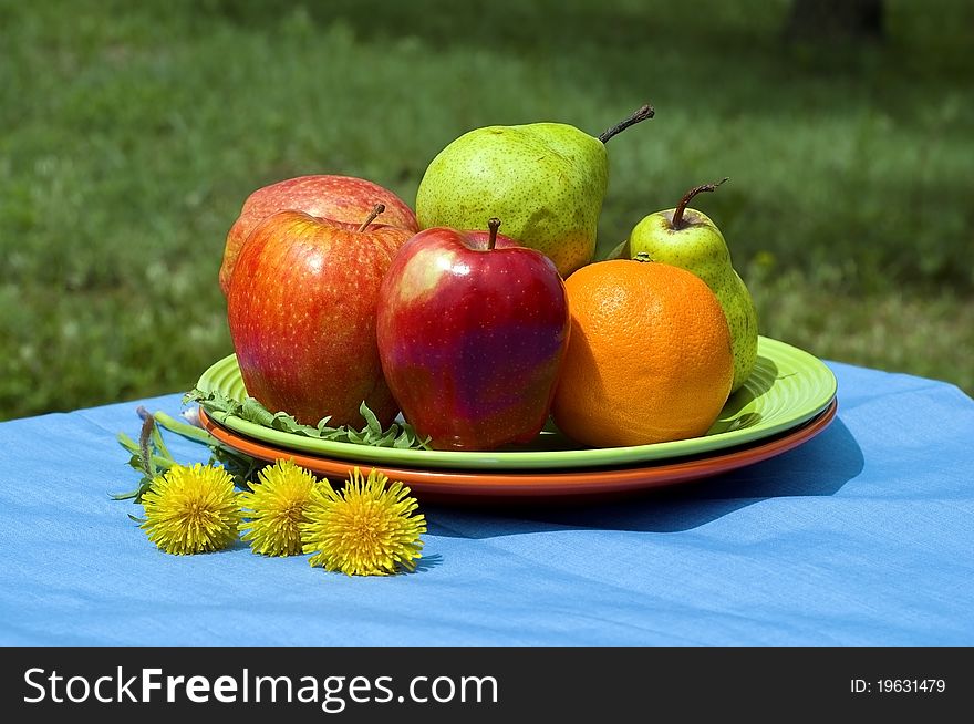 Plate of fruits in tha garden setting. Plate of fruits in tha garden setting