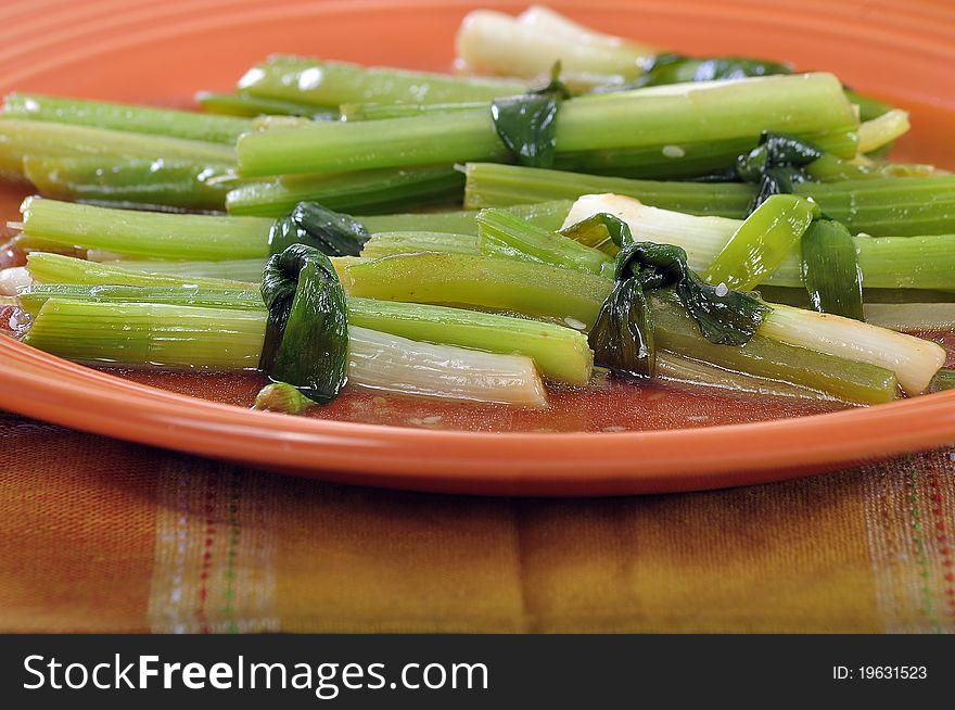 Bundles of young onion and celery sticks in sauce. Bundles of young onion and celery sticks in sauce
