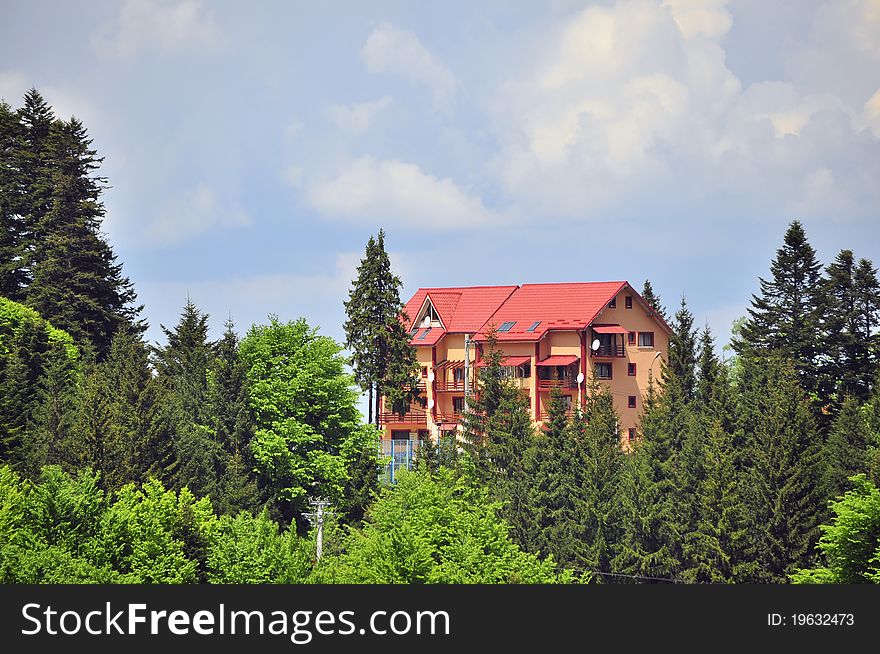 Red wooden cottage in the forest on mountain top. Red wooden cottage in the forest on mountain top